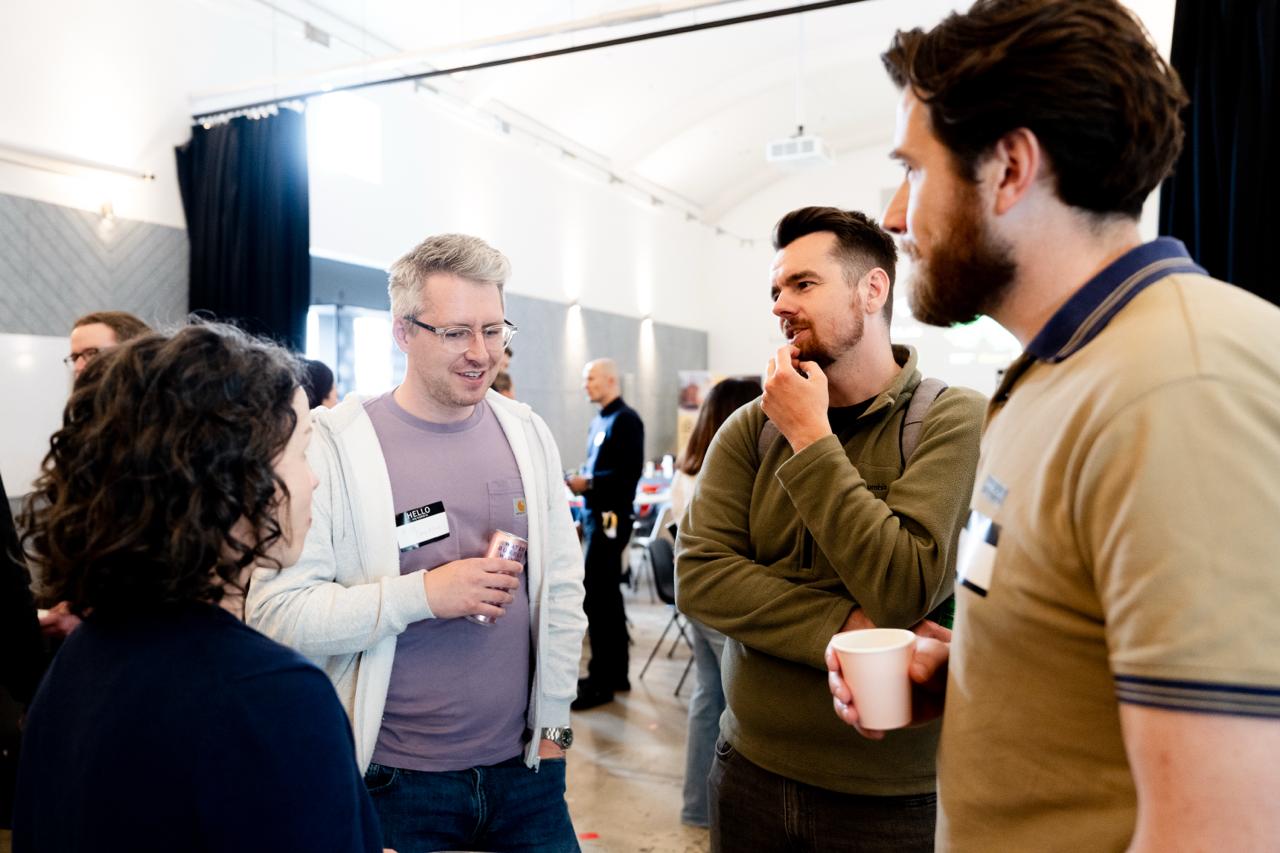 Four founders in conversation, side of room