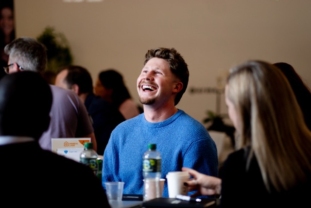 Founder laughing at table